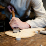 Holzplatte wird mit einem Messer abgehobelt